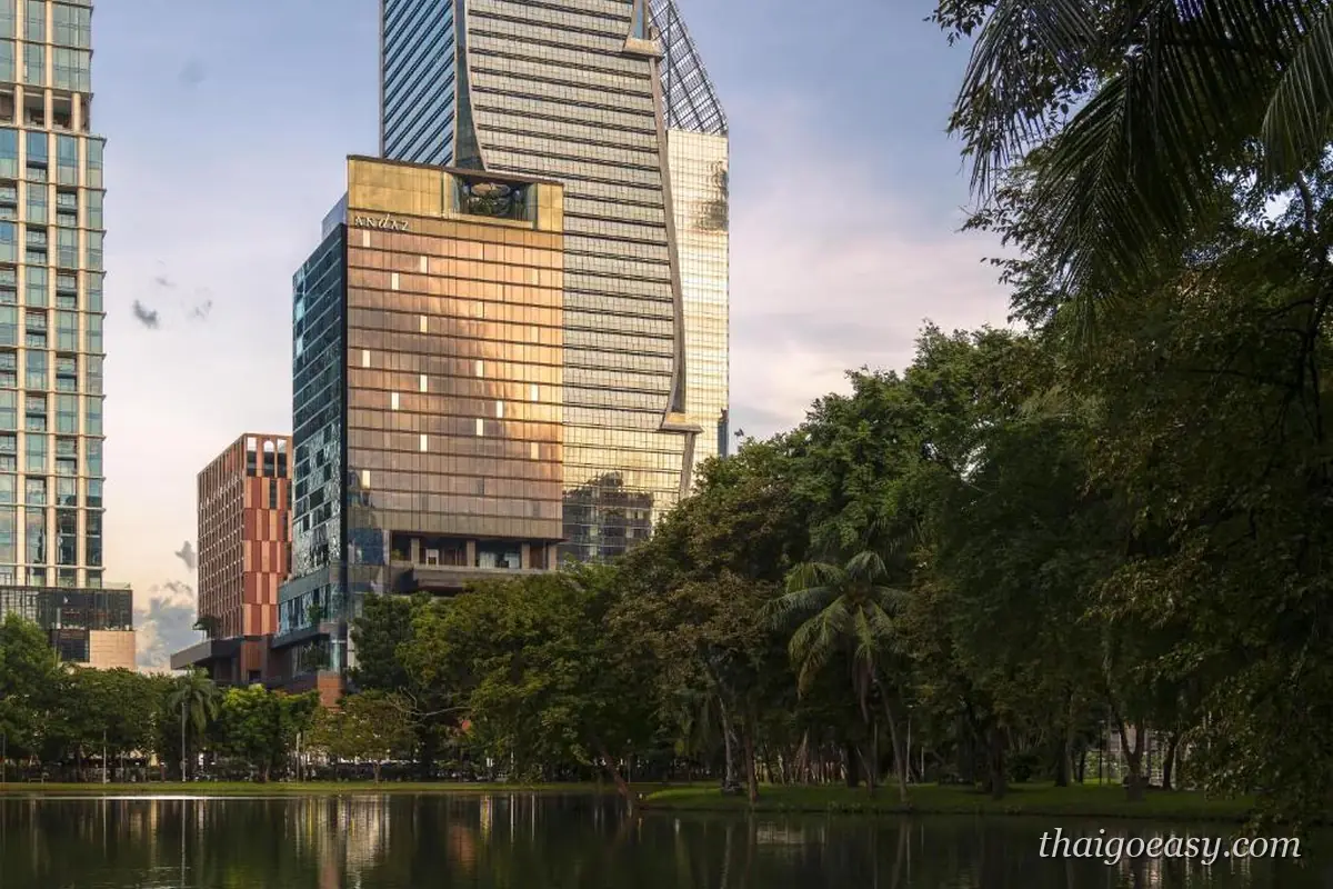 Andaz One Bangkok 高樓外觀，前景是倫披尼公園的水池與棕櫚樹