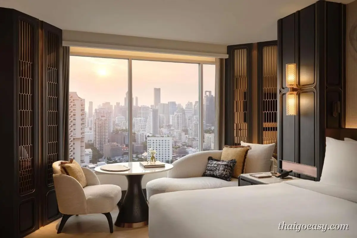 Fairmont Bangkok Sukhumvit 客房，落地窗外是日落時分的曼谷市景