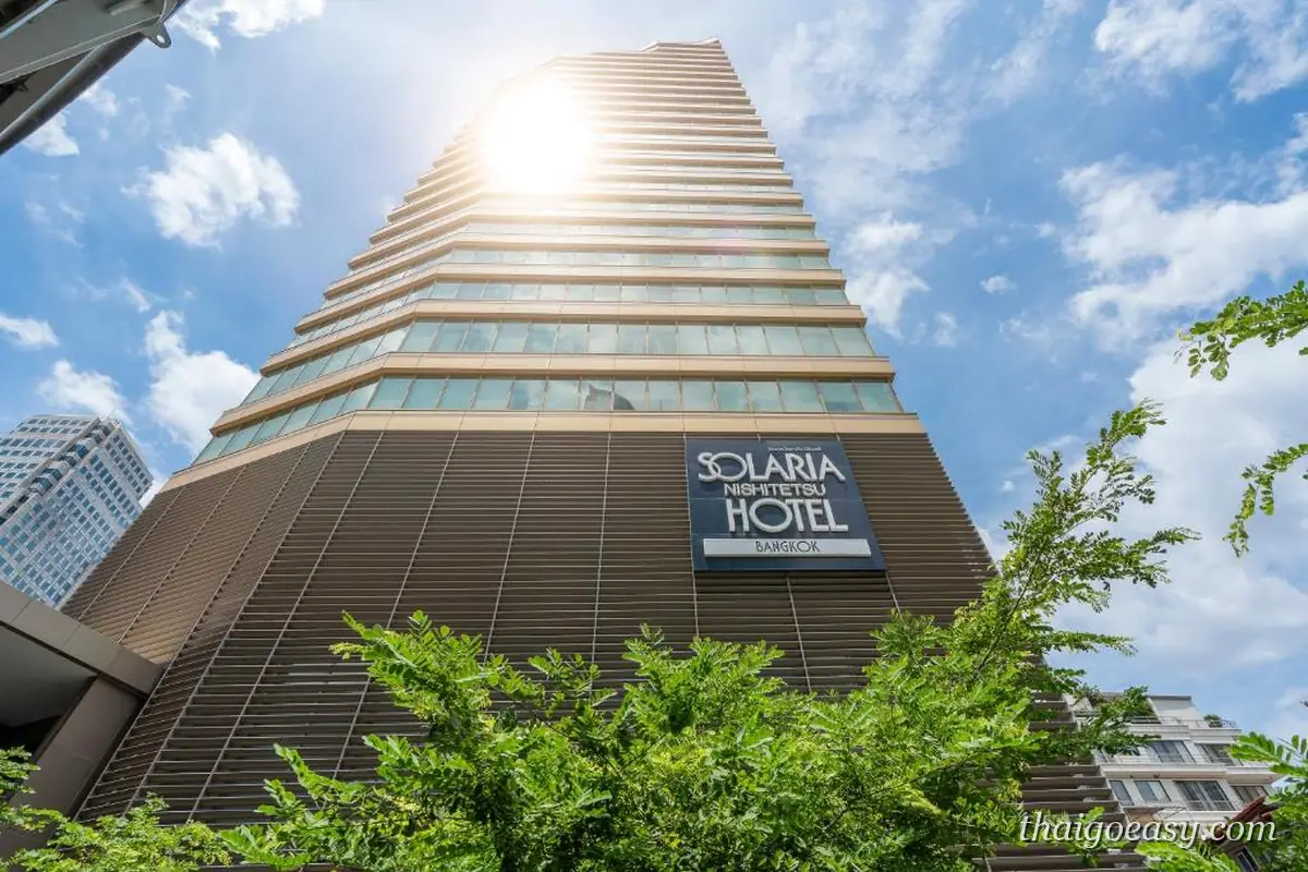 仰角拍攝曼谷索拉利亞西鐵飯店的高樓，樓體掛著 SOLARIA NISHITETSU HOTEL 招牌