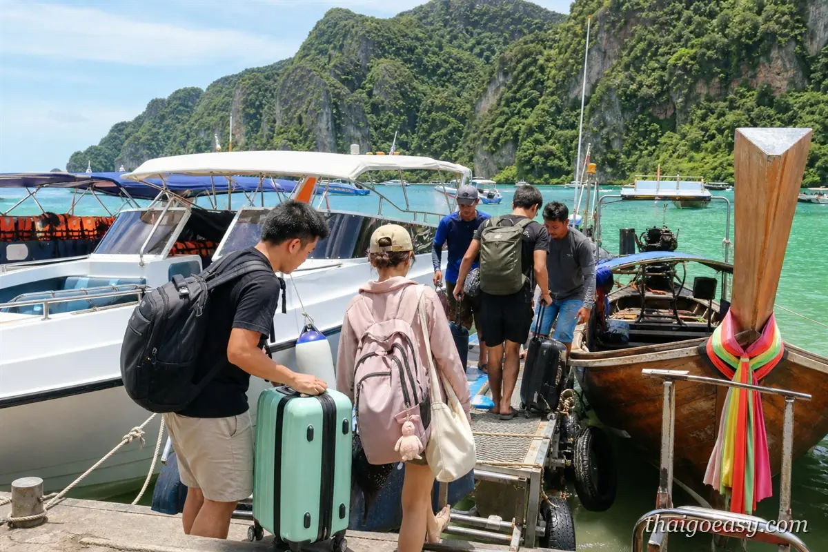 碼頭邊旅客提著行李箱準備登上快艇，周圍停著多艘跳島船