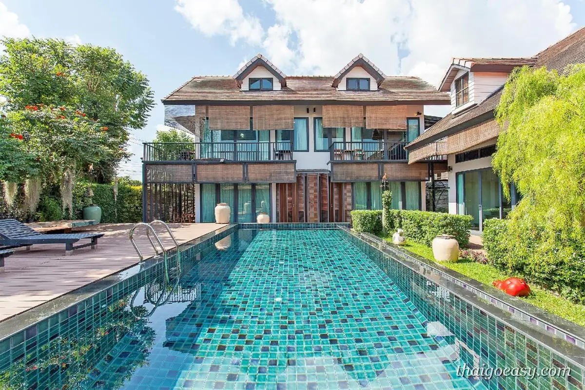 Sunshine Pool Villa 的雙層木造別墅，前方是自己專屬的長方形碧綠泳池與木頭平台