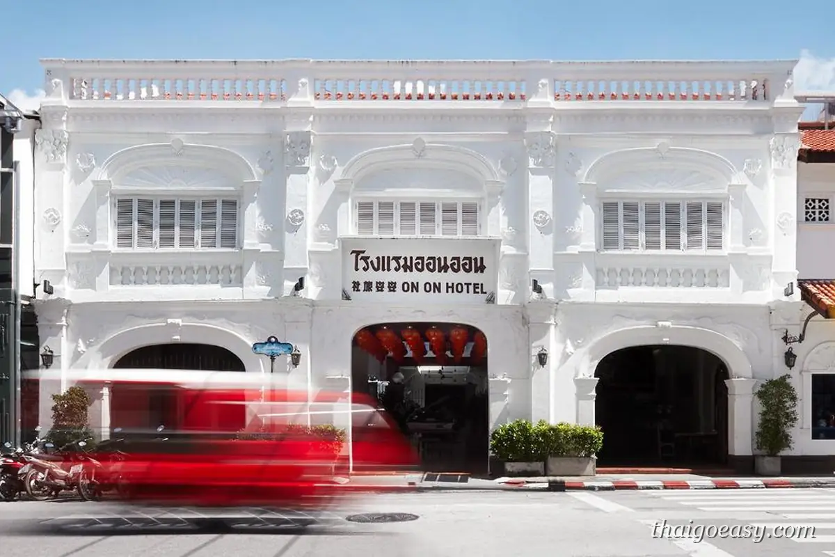 普吉老鎮 On On Hotel 的白色 Sino-Portuguese 立面，招牌寫著 ON ON HOTEL，門前有嘟嘟車駛過