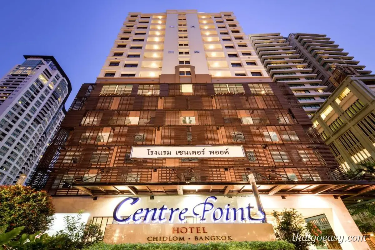 曼谷中心點奇隆飯店入口，招牌寫著 Centre Point Hotel Chidlom Bangkok，立面是深色木格柵